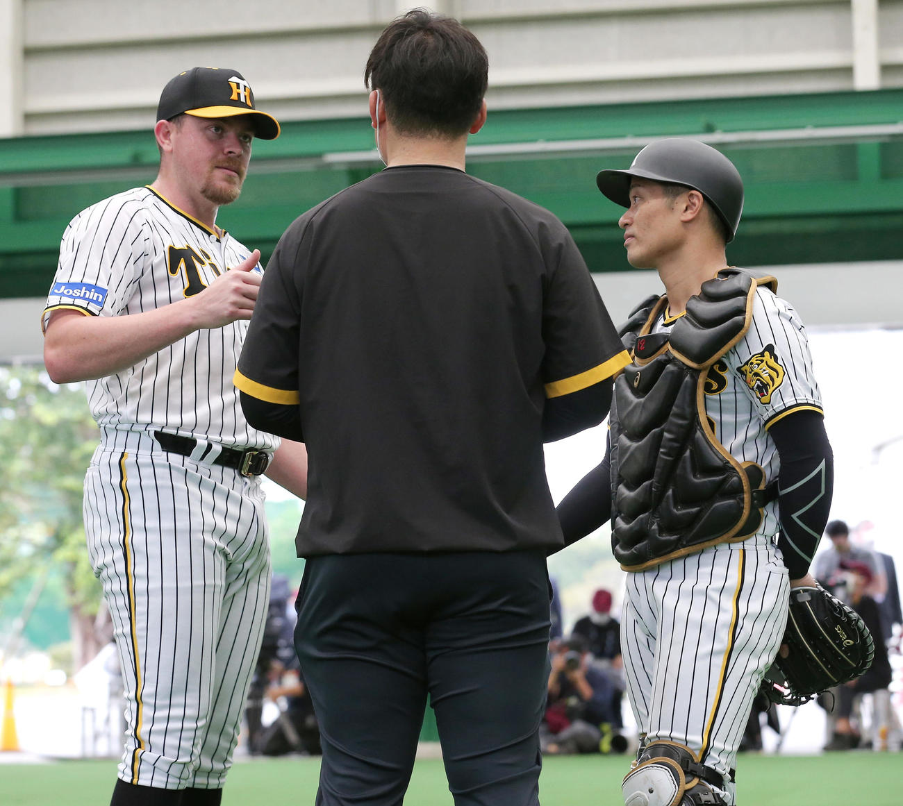 ブルペンで投球を終えたビーズリー（左）は坂本と話す（撮影・上山淳一）