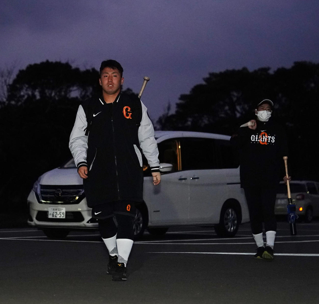 早朝練習のため、午前6時43分、室内練習場に到着した巨人ドラフト1位の浅野。右は松原（撮影・江口和貴）