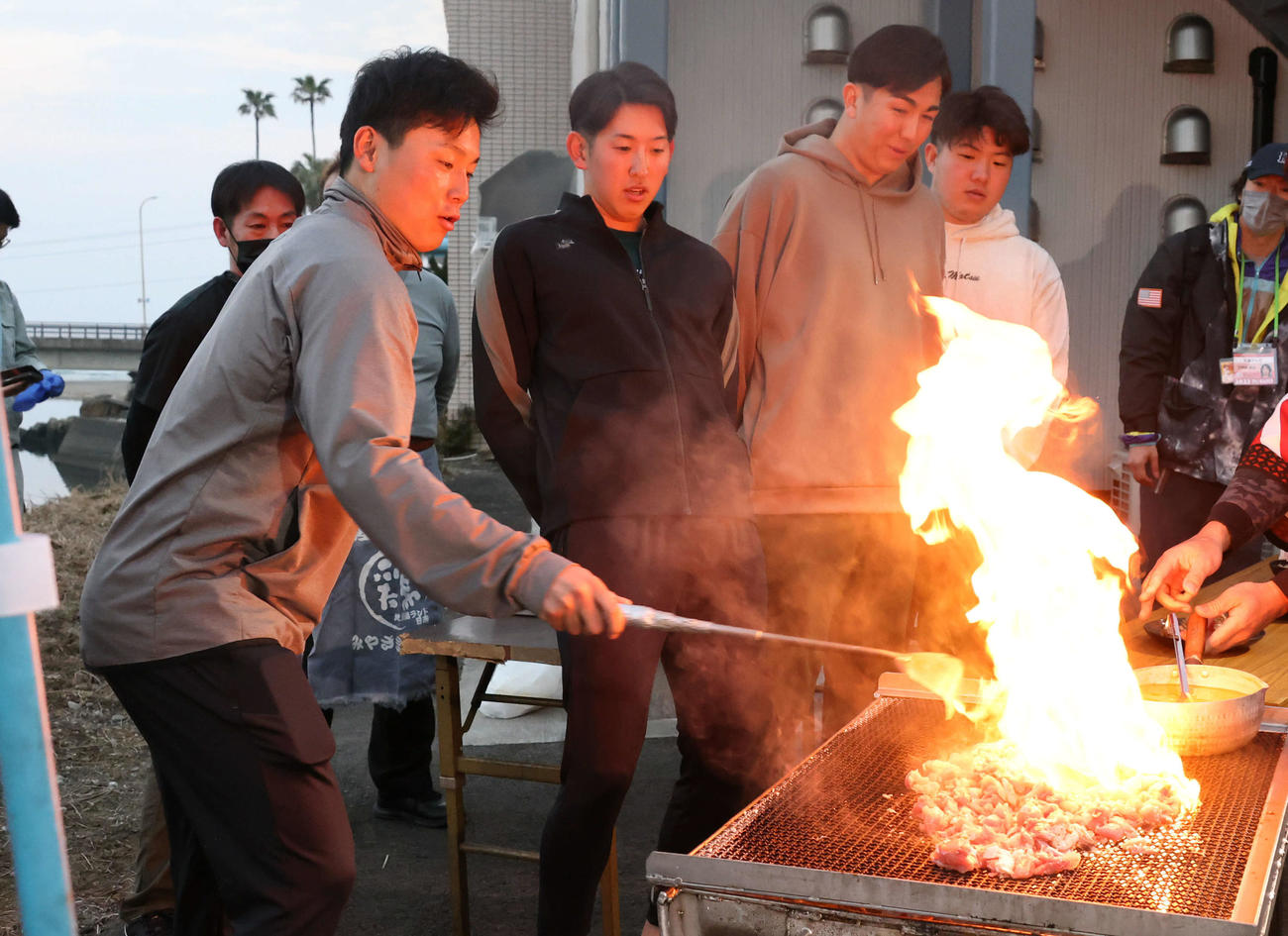地鶏を焼いて立ち上がる炎に驚く広島の選手たち。左から栗林、遠藤、ケムナ、松本（撮影・加藤孝規）
