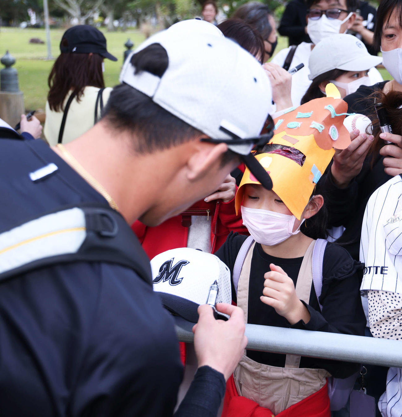 鬼の面をかぶった子どもにサインを書くロッテ高部（撮影・河田真司）