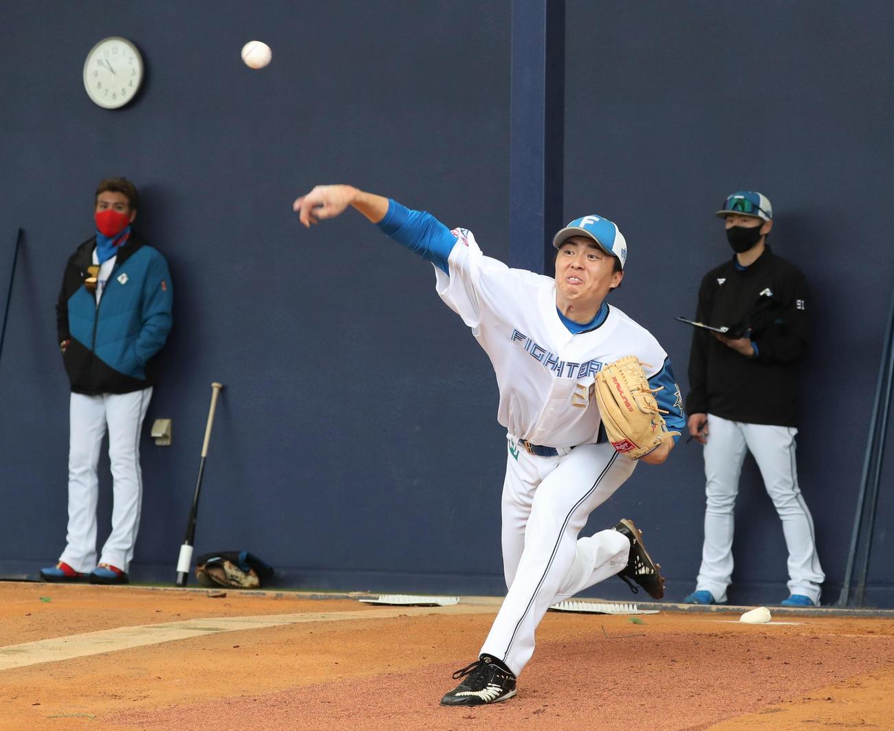 ブルペンで投球する日本ハム田中正。左は新庄監督（撮影・黒川智章）