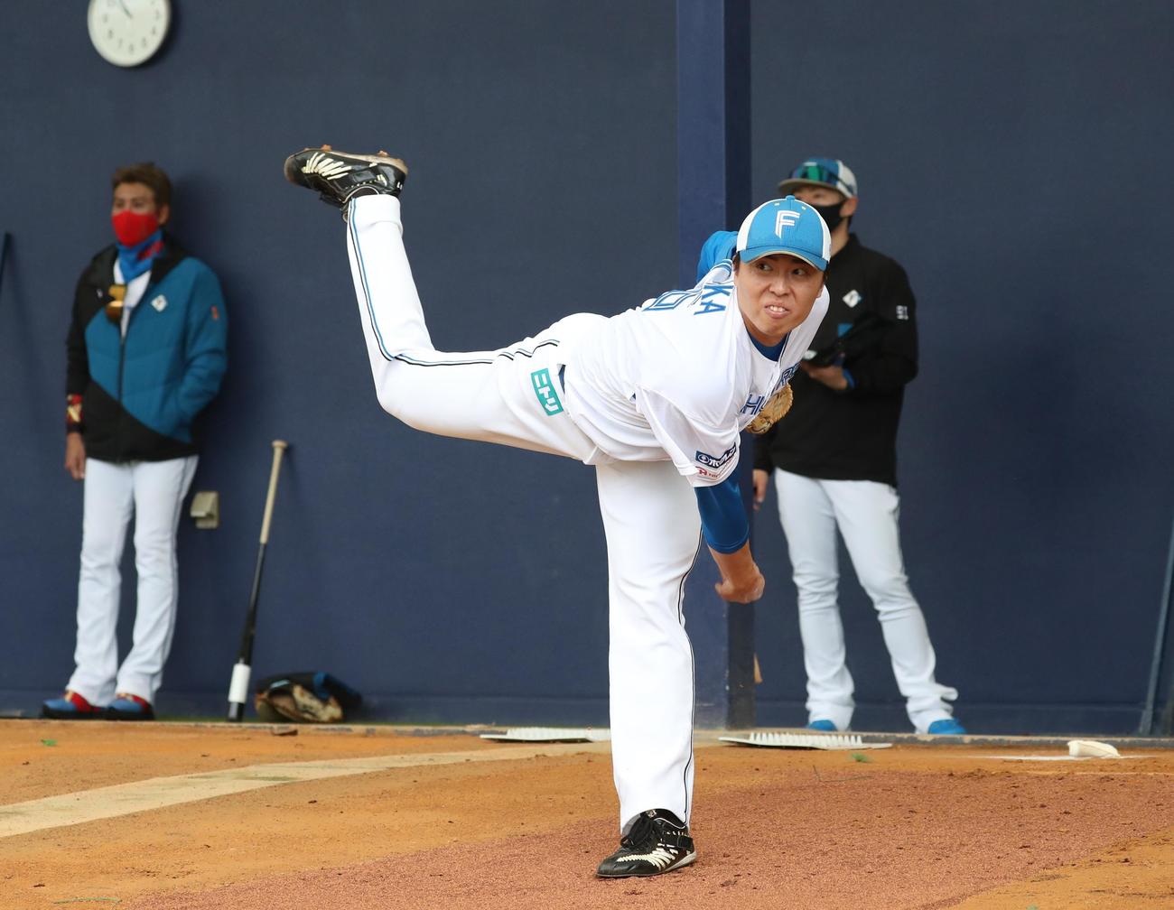 ブルペン投球する日本ハム田中正。左は新庄監督（撮影・黒川智章）
