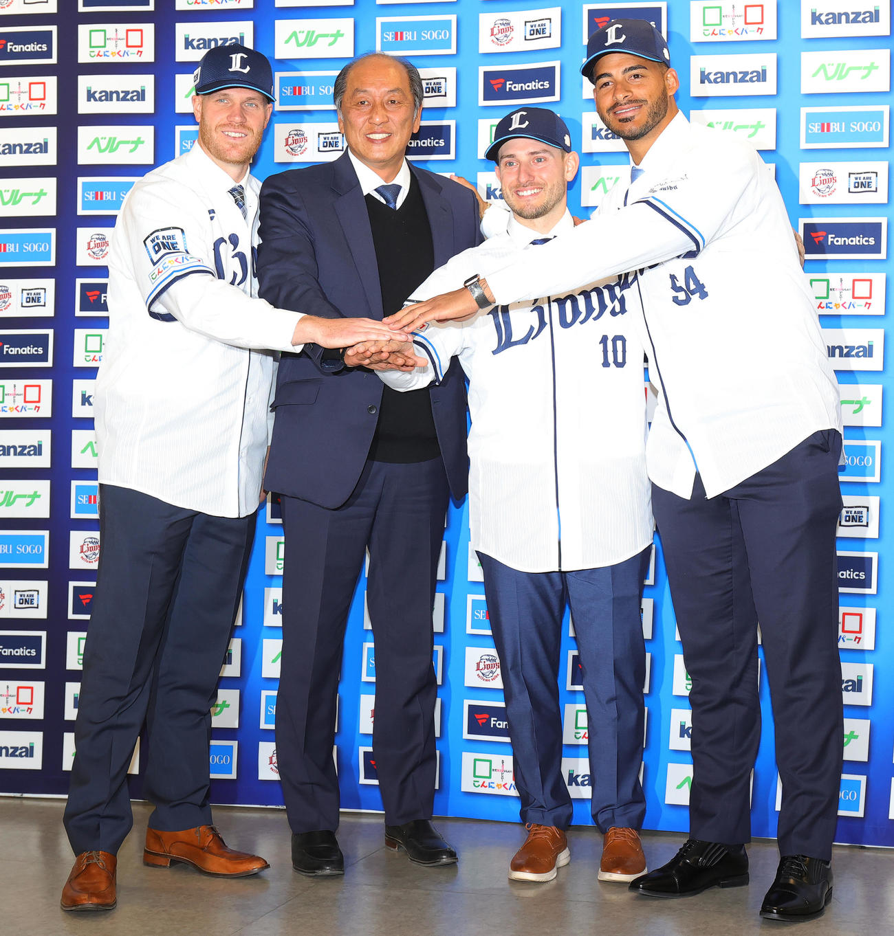 入団会見で手を合わせる西武の新外国人選手たち。左からマキノン内野手、渡辺GM、ペイトン外野手、ティノコ投手（撮影・野上伸悟）