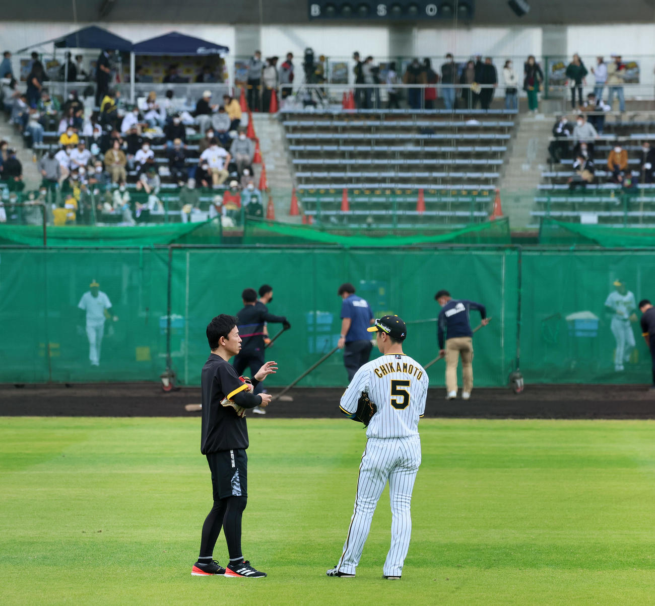 近本はノックを終えて赤星臨時コーチ（左）と中堅で話し込む（撮影・加藤哉）
