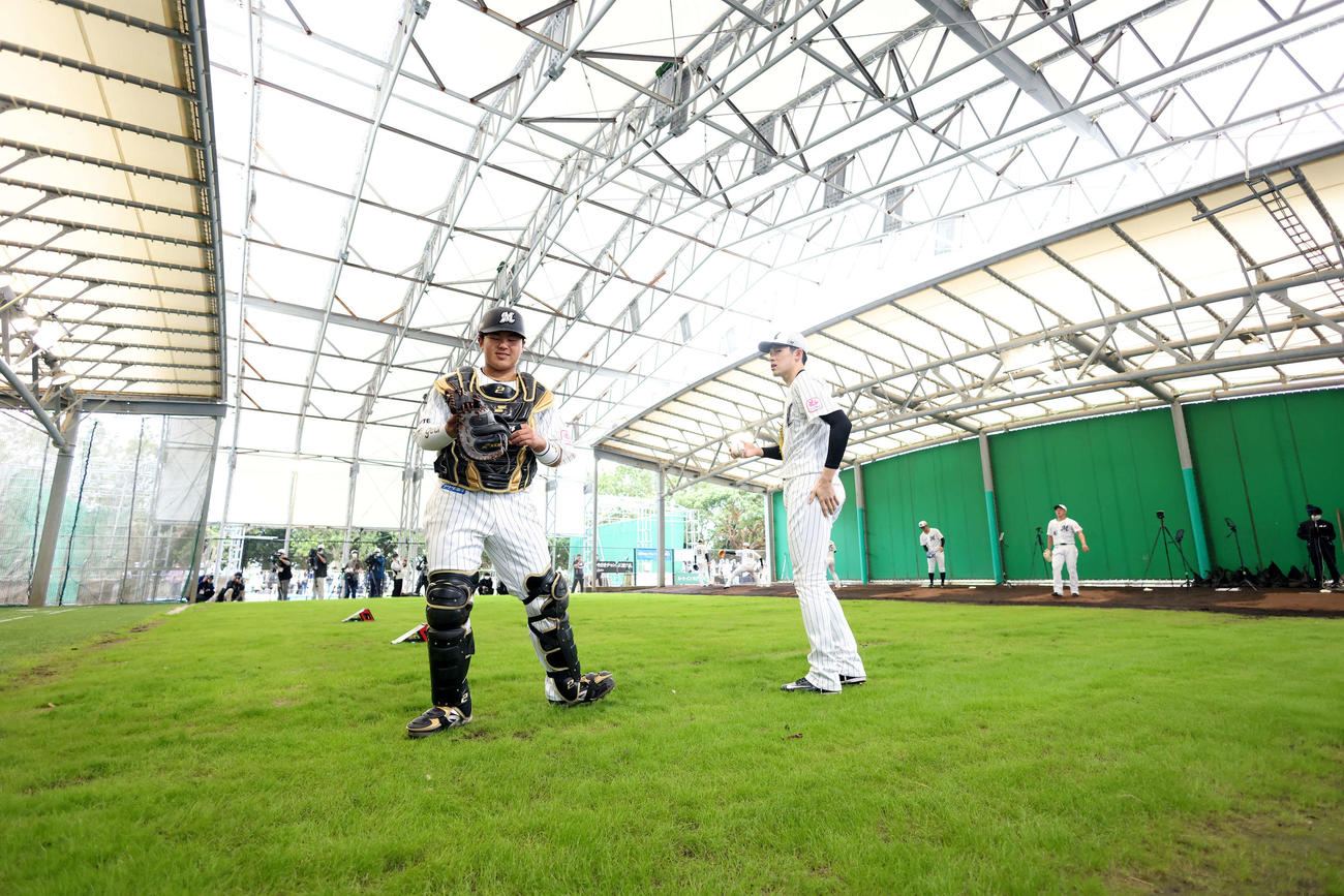 ブルペンで言葉を交わすロッテ松川（左）と佐々木朗（撮影・河田真司）