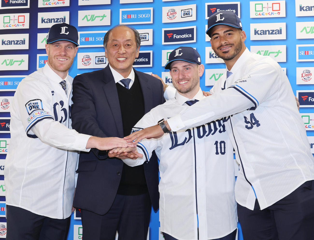 入団会見で手を合わせる西武の新外国人選手たち。左からマキノン内野手、渡辺GM、ペイトン外野手、ティノコ投手（撮影・野上伸悟）