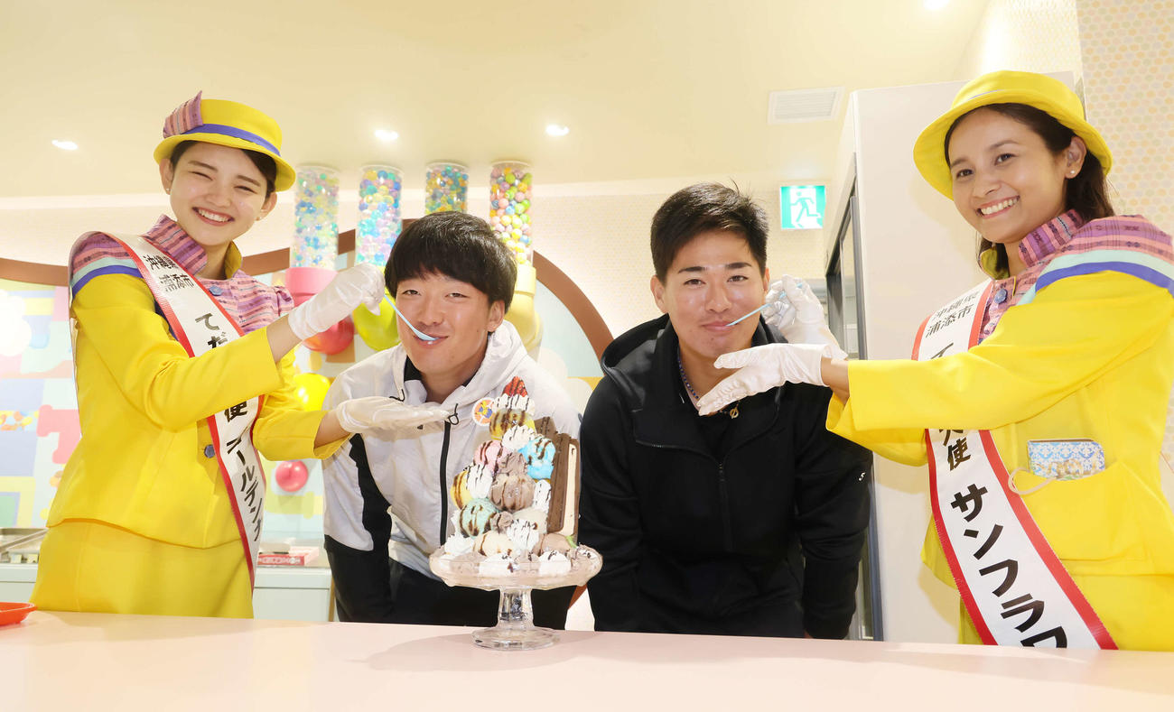 キャンプ休日にブルーシールアイスを訪れ「てだこ大使」の本村杏珠さん（左端）と宮城あずささん（右端）からアイスを食べさせてもらうヤクルトドラフト1位吉村（中央左）と同5位北村（撮影・足立雅史）