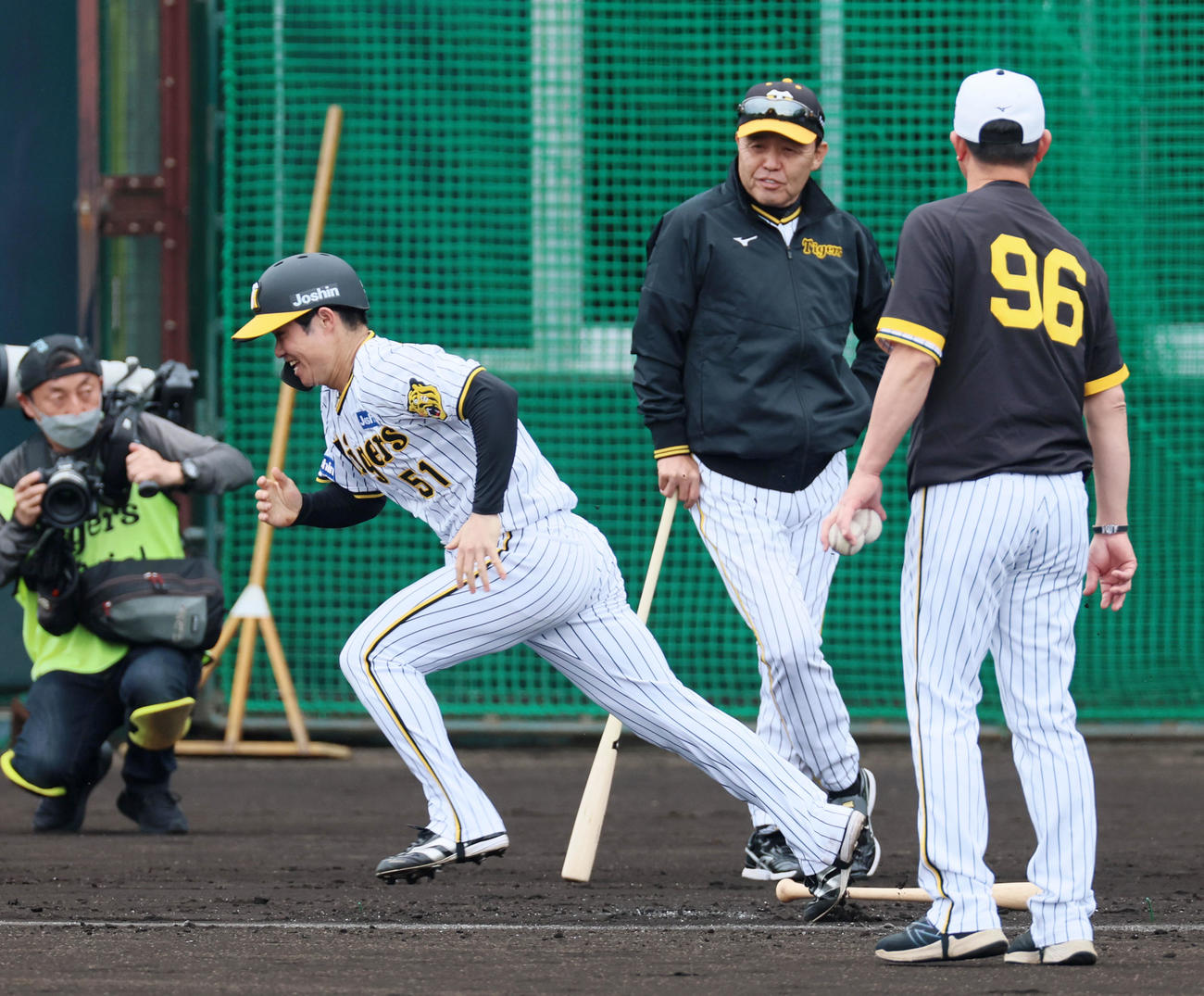 走塁練習で筒井コーチのトスボールを打って走り出す中野。右は岡田監督（撮影・加藤哉）
