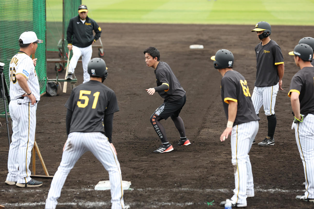 阪神中野（手前左）らに走塁指導する赤星臨時コーチ（中央）。奥は見守る岡田監督（撮影・前田充）