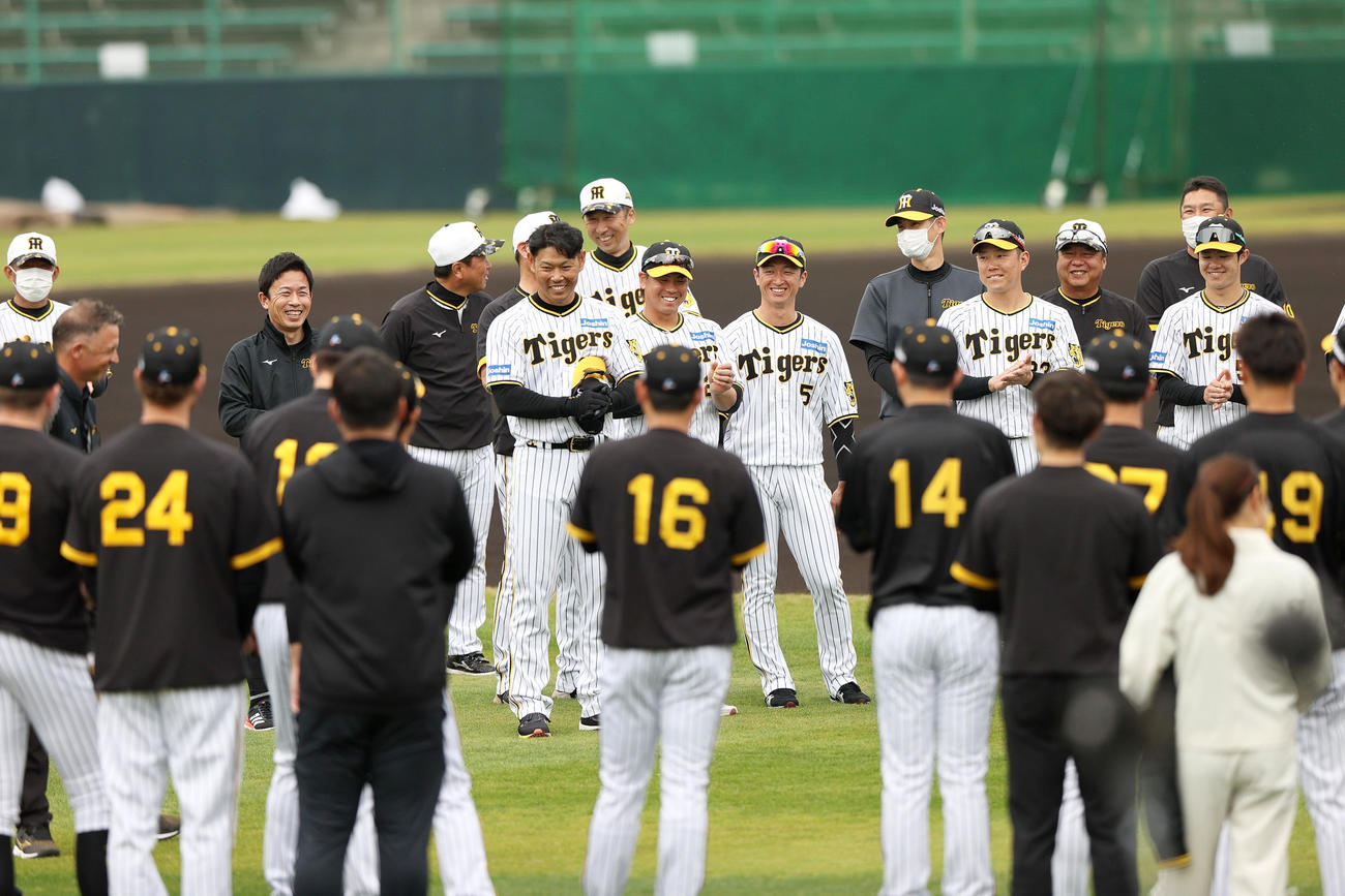 宜野座に訪れたウィリアムス阪神駐米スカウト（左から3人目）と臨時コーチの赤星氏（左から5人目）を出迎える阪神ナイン（撮影・上山淳一）