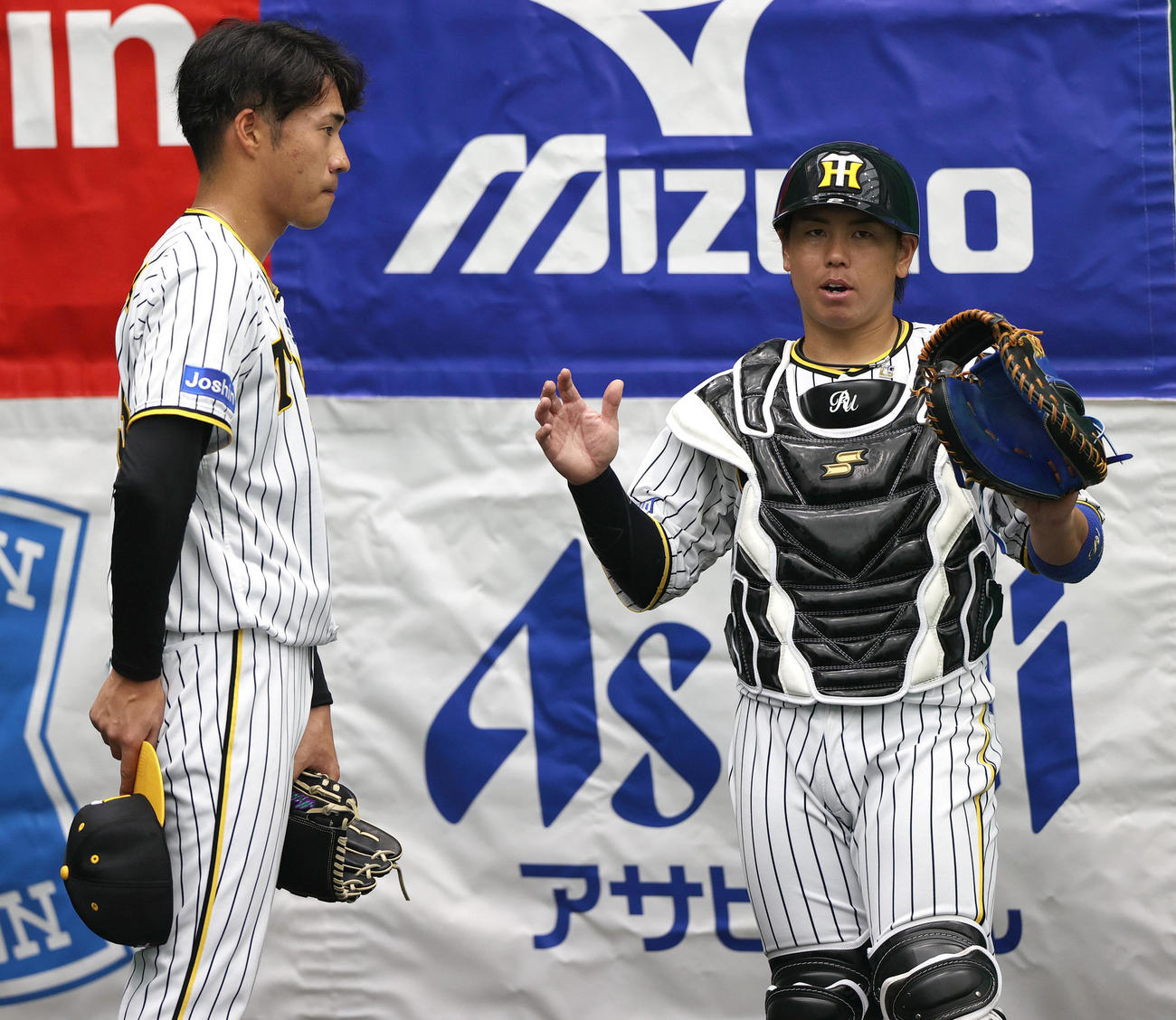 ブルペンで投球を終えた岩田（左）にアドバイスする梅野（撮影・上山淳一）