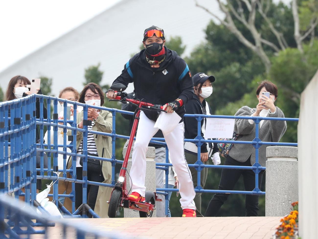 キックボードで球場入りする日本ハム新庄監督（撮影・黒川智章）