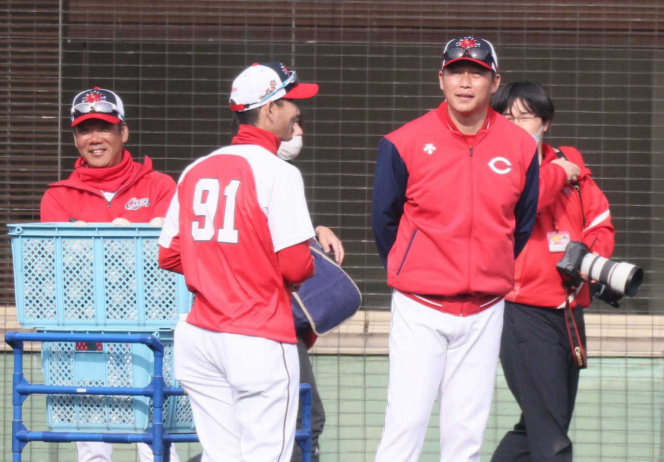 広島日南キャンプ　ロングティーを見守る新井監督（右）と藤井ヘッドコーチ（左）。中央は迎打撃コーチ（撮影・加藤孝規）