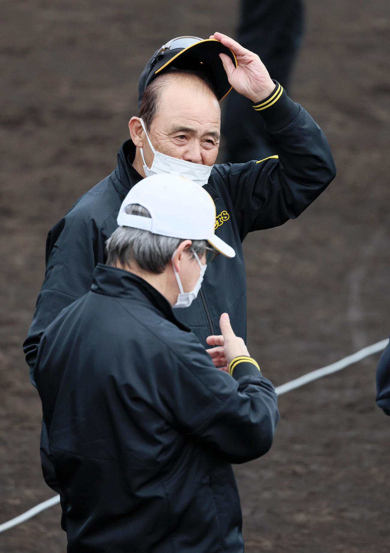 具志川野球場で杉山オーナー（右）と話す岡田監督（撮影・加藤哉）