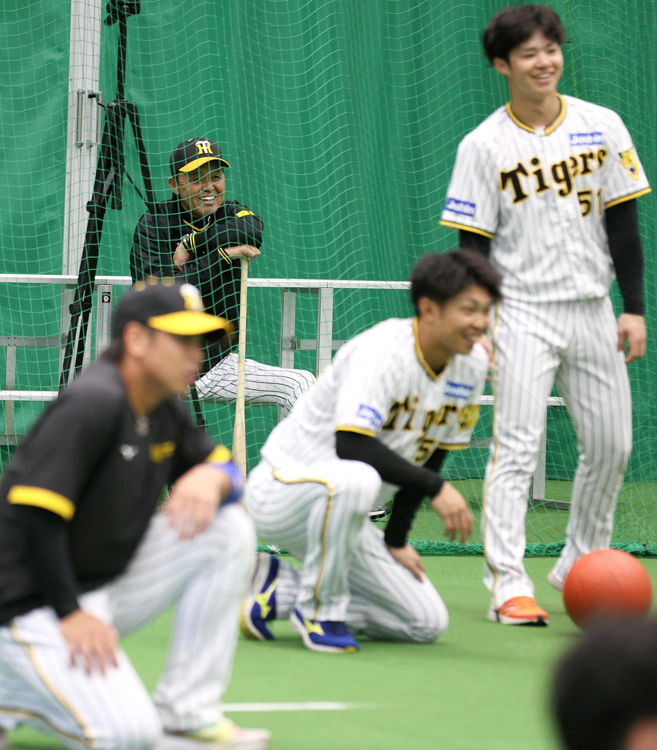 体幹トレーニングで苦しむミエセスを見て笑顔を見せる岡田監督（奥）らナイン（撮影・上山淳一）