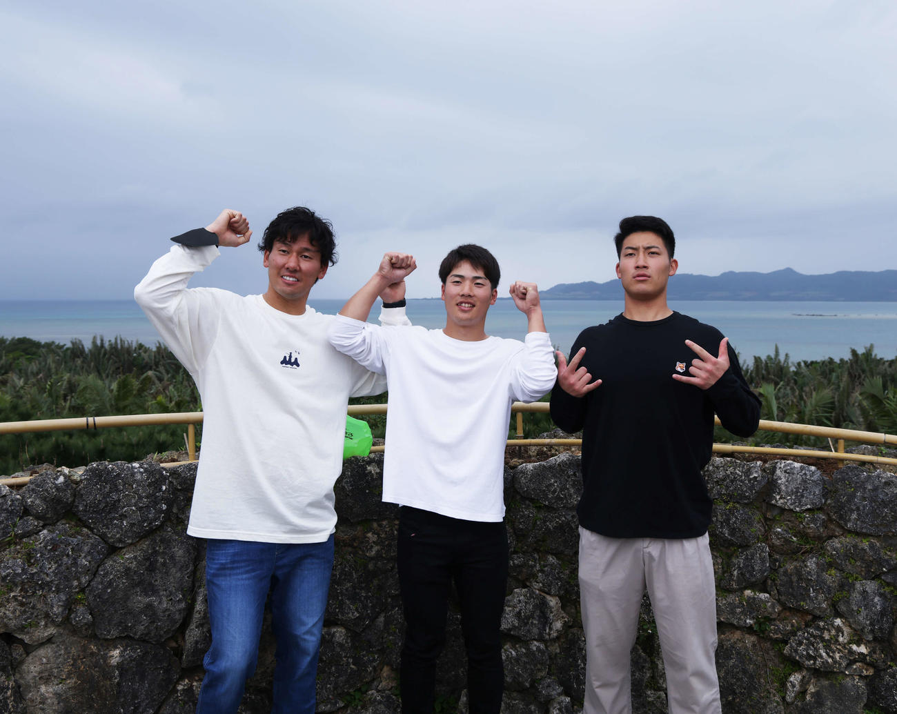 海をバックに記念撮影するロッテの、左から高野、友杉、菊地（撮影・河田真司）