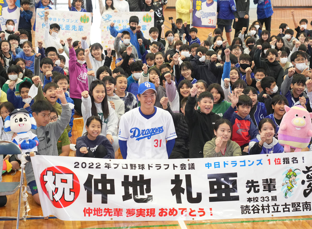 休日に母校を訪れ子どもたちと記念写真に納まる仲地（前列中央）（撮影・森本幸一）
