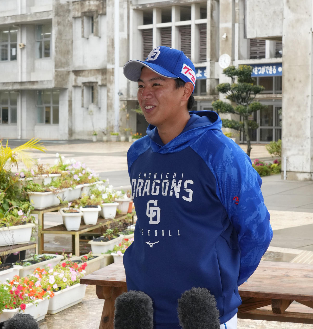 休日に母校を訪れ児童と交流し取材に応じる仲地（撮影・森本幸一）