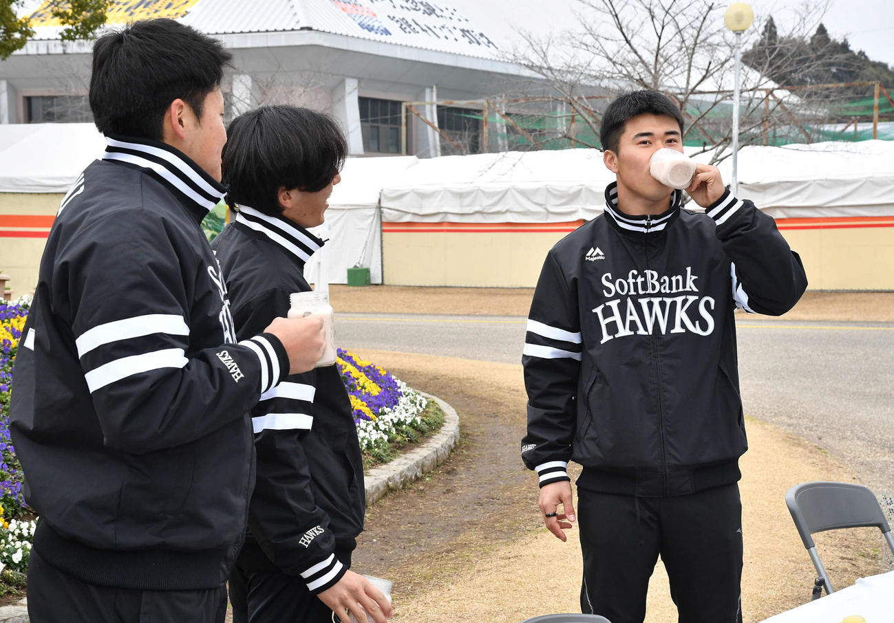 キャンプ休日の新人選手体験で、作ったフルーツミックスジュースを一気飲みする松本晴（右）を見つめる左から生海、大津（撮影・岩下翔太）