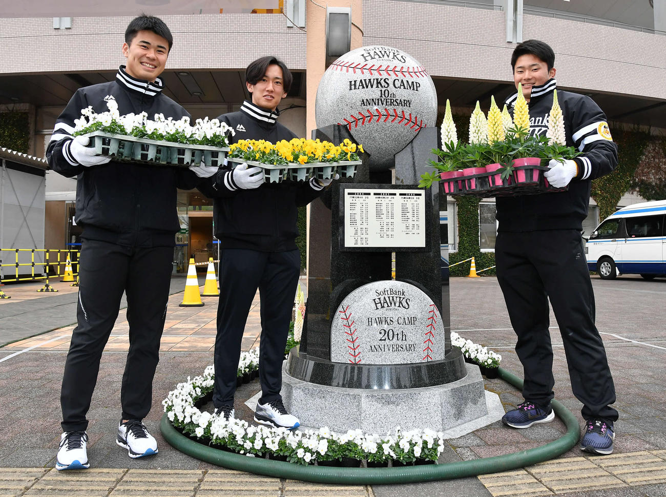 キャンプ休日の新人選手体験で、ソフトバンクの宮崎キャンプ20周年記念モニュメントを花で装飾する、左から松本晴、大津、生海（撮影・岩下翔太）