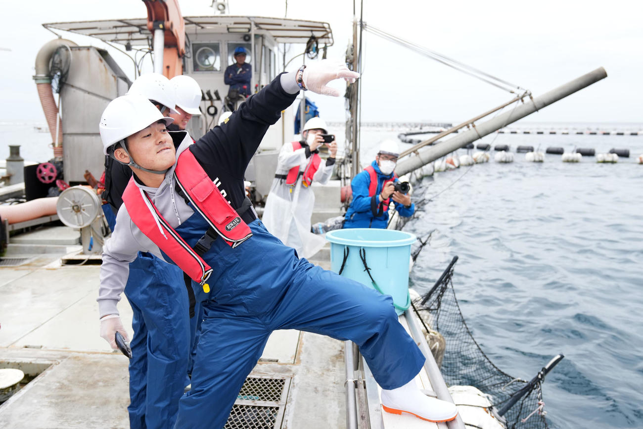 本マグロ養殖場でエサを投げ入れるDeNA林（撮影・横山健太）
