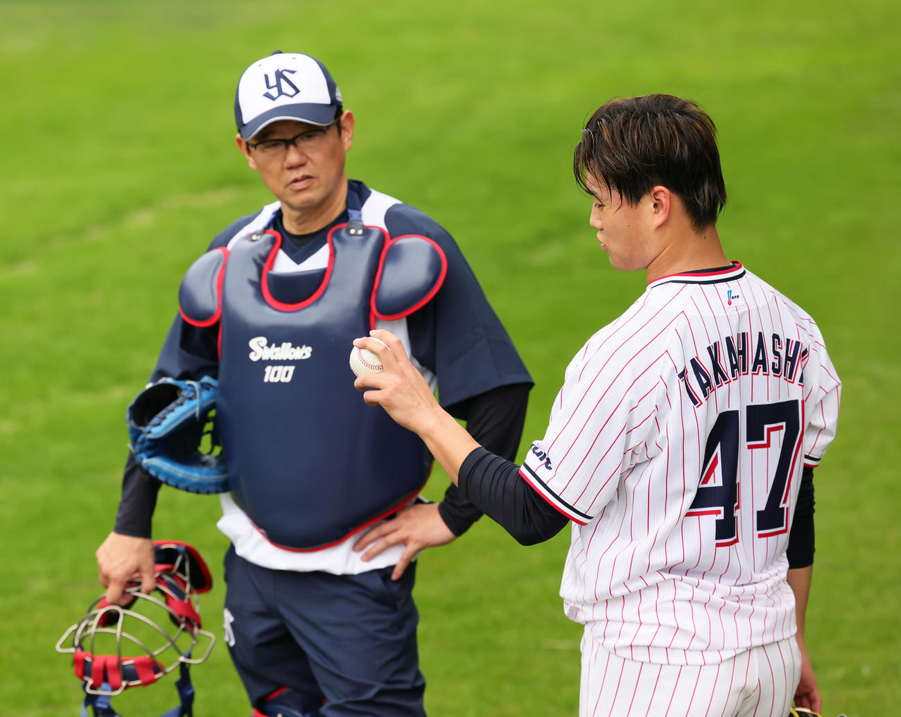 ブルペン投球を終えたヤクルト高橋（右）は臨時コーチの古田氏と会話を交わす（撮影・足立雅史）