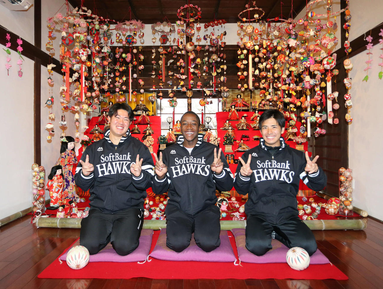 ひな人形の前で笑顔でピースをする左から吉田、イヒネ、大野（撮影・屋方直哉）
