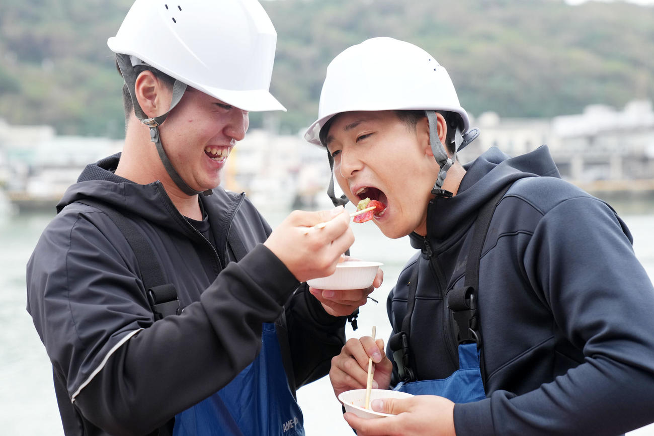 本マグロの刺身をDeNA橋本（左）から食べさせてもらう松尾（撮影・横山健太）