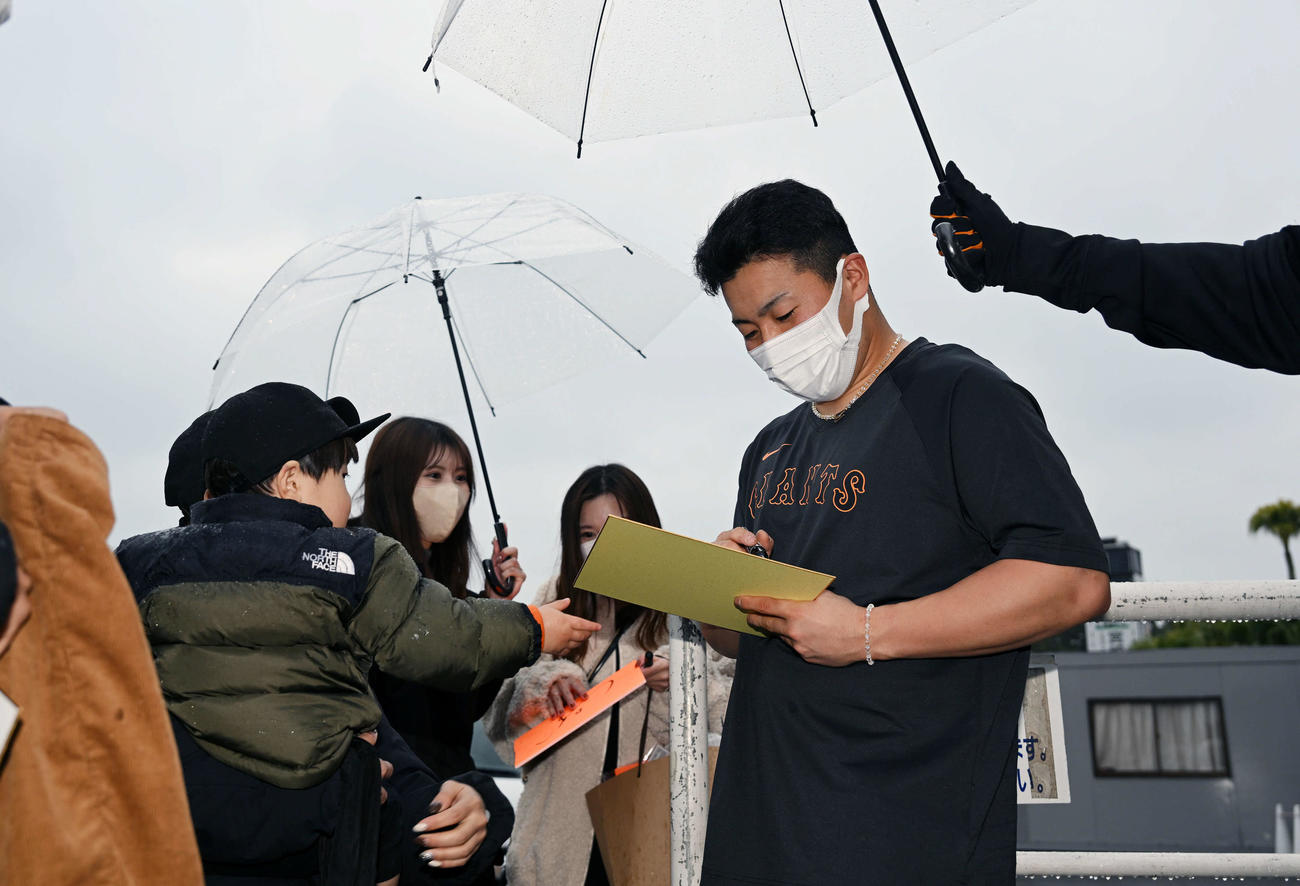 雨の中、ファンのサインに応じる巨人ドラフト1位浅野（撮影・滝沢徹郎）