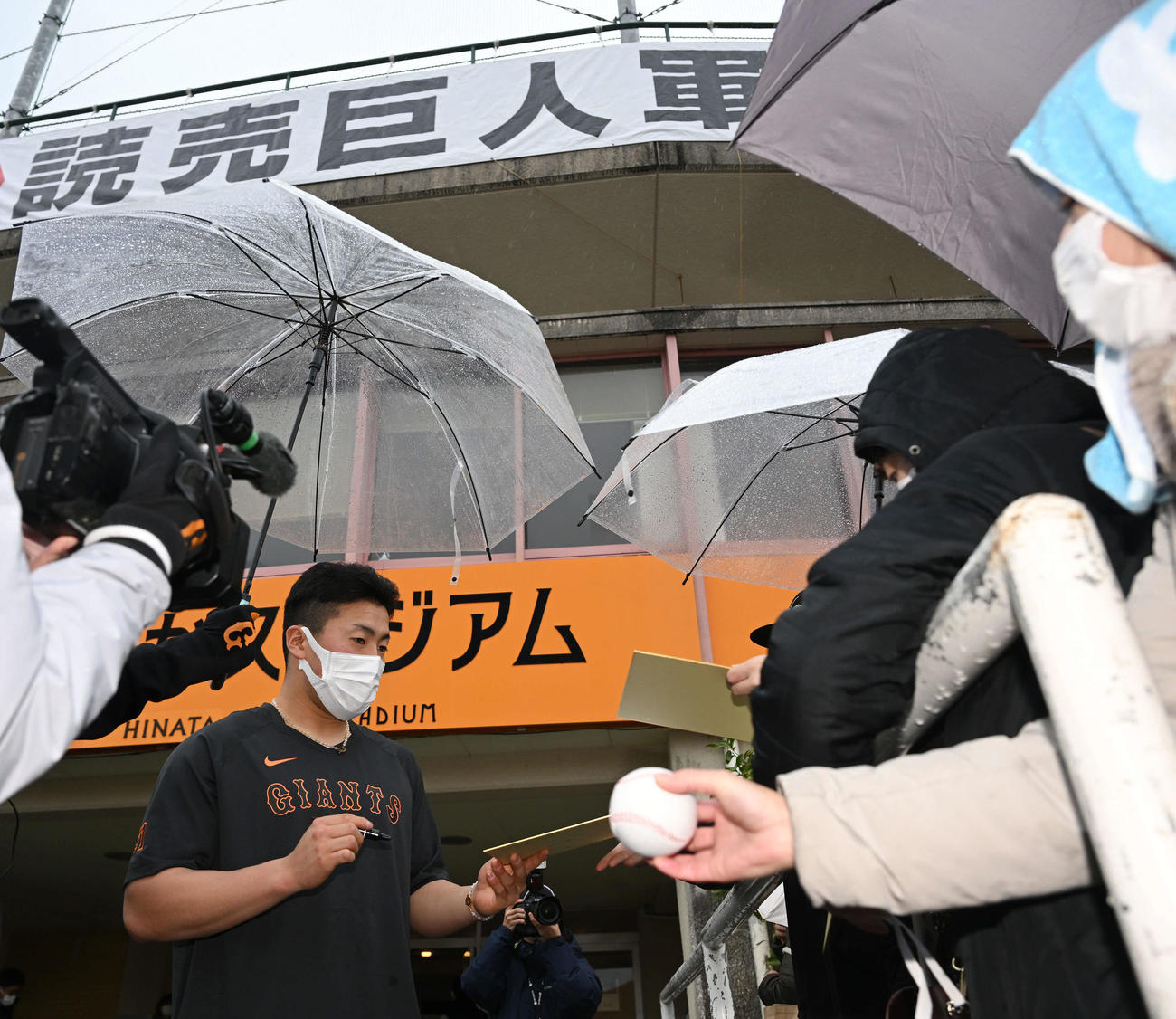 雨の中、ファンのサインに応じる巨人ドラフト1位浅野（撮影・滝沢徹郎）