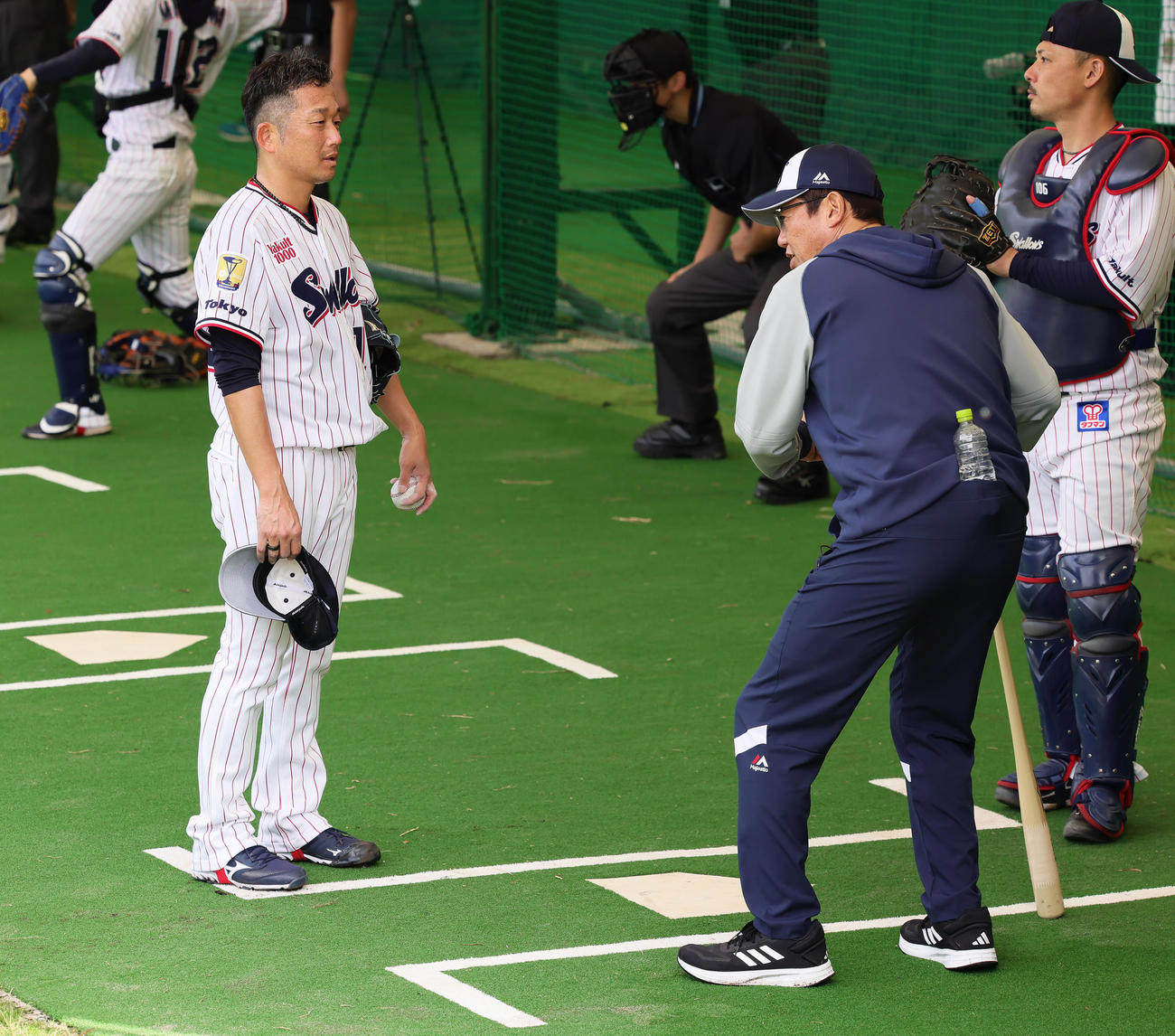 ブルペン投球を終えたヤクルト石川（左）は古田臨時コーチからアドバイスを受ける（撮影・足立雅史）