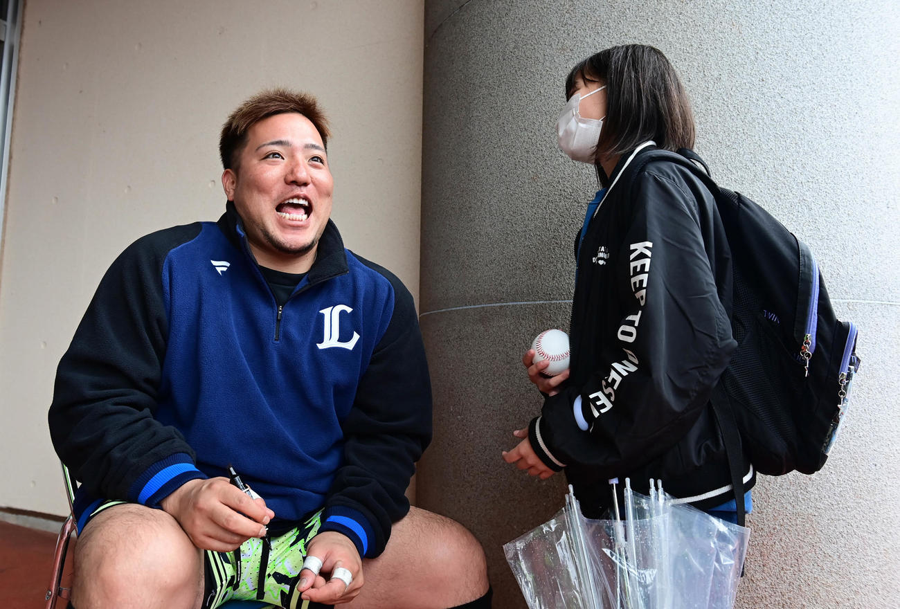 練習途中でサイン会を開いた西武山川（左）は都城市から来たという女の子に「好きな選手はだれ？」と問い掛け耳を傾けた。他の選手の名前を言ったのか自らの名前を言ってもらったのかは定かではありませんが、満面の笑みを浮かべて周囲を和ませた（撮影・小沢裕）