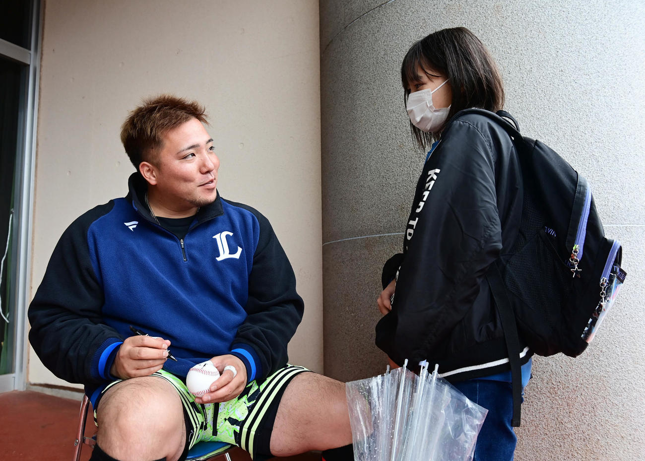 練習途中でサイン会を開いた西武山川（左）は都城市から来たという女の子と言葉を交わす（撮影・小沢裕）