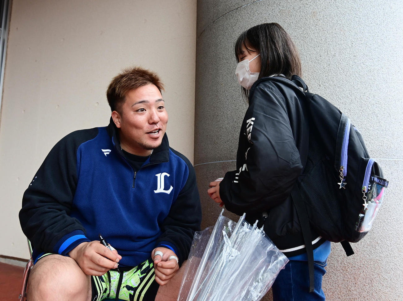練習途中でサイン会を開いた西武山川（左）は都城市から来たという女の子に「好きな選手はだれ？」と問い掛け耳を傾ける（撮影・小沢裕）