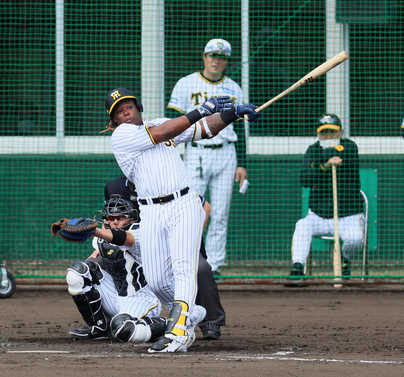 シート打撃練習の無死からノイジーに続いて左越え本塁打を放ったミエセス。右は岡田監督（撮影・加藤哉）