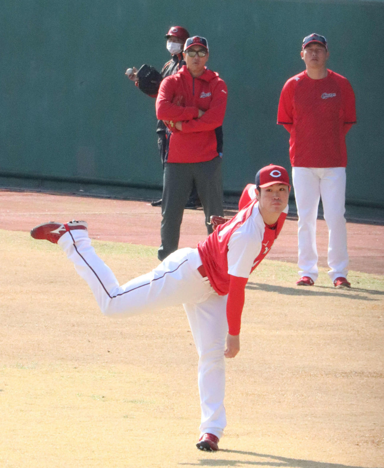 黒田博樹球団アドバイザー（後方左）と新井貴浩監督（同右）が見つめる中、キャッチボールする広島ドラフト1位斉藤優汰投手（撮影・前原淳）