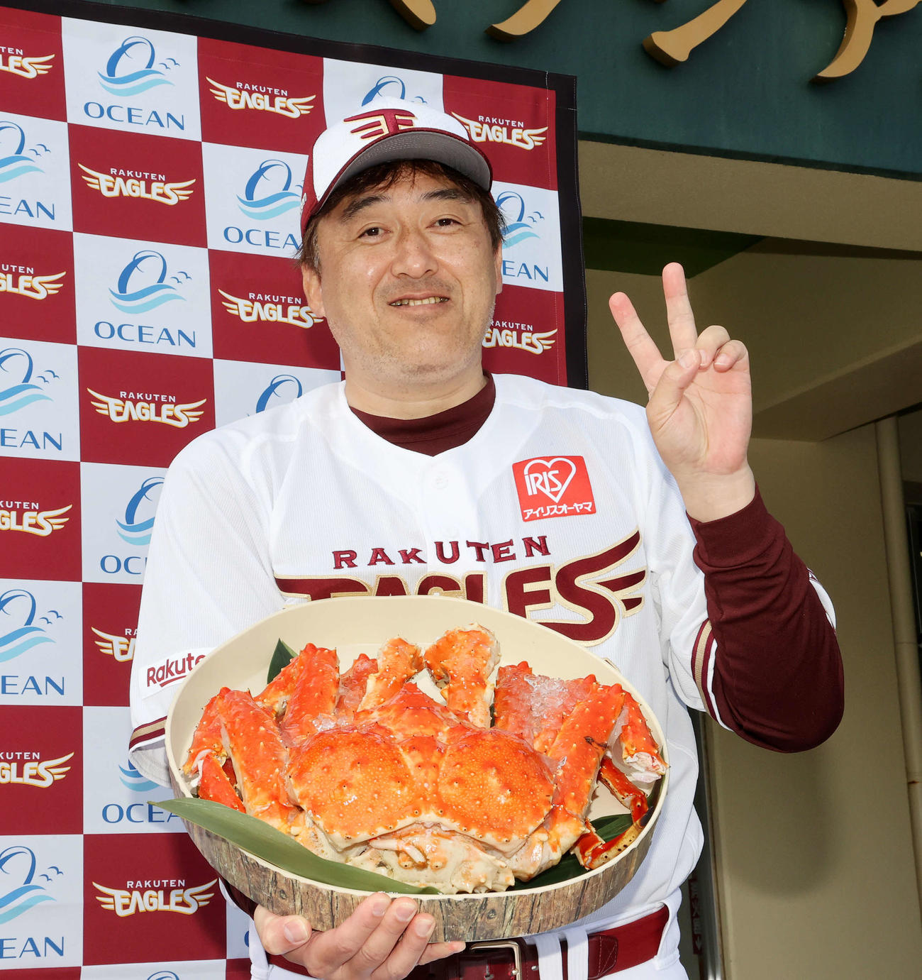 贈呈されたカニを手に笑顔を見せる楽天石井監督（撮影・鈴木正人）