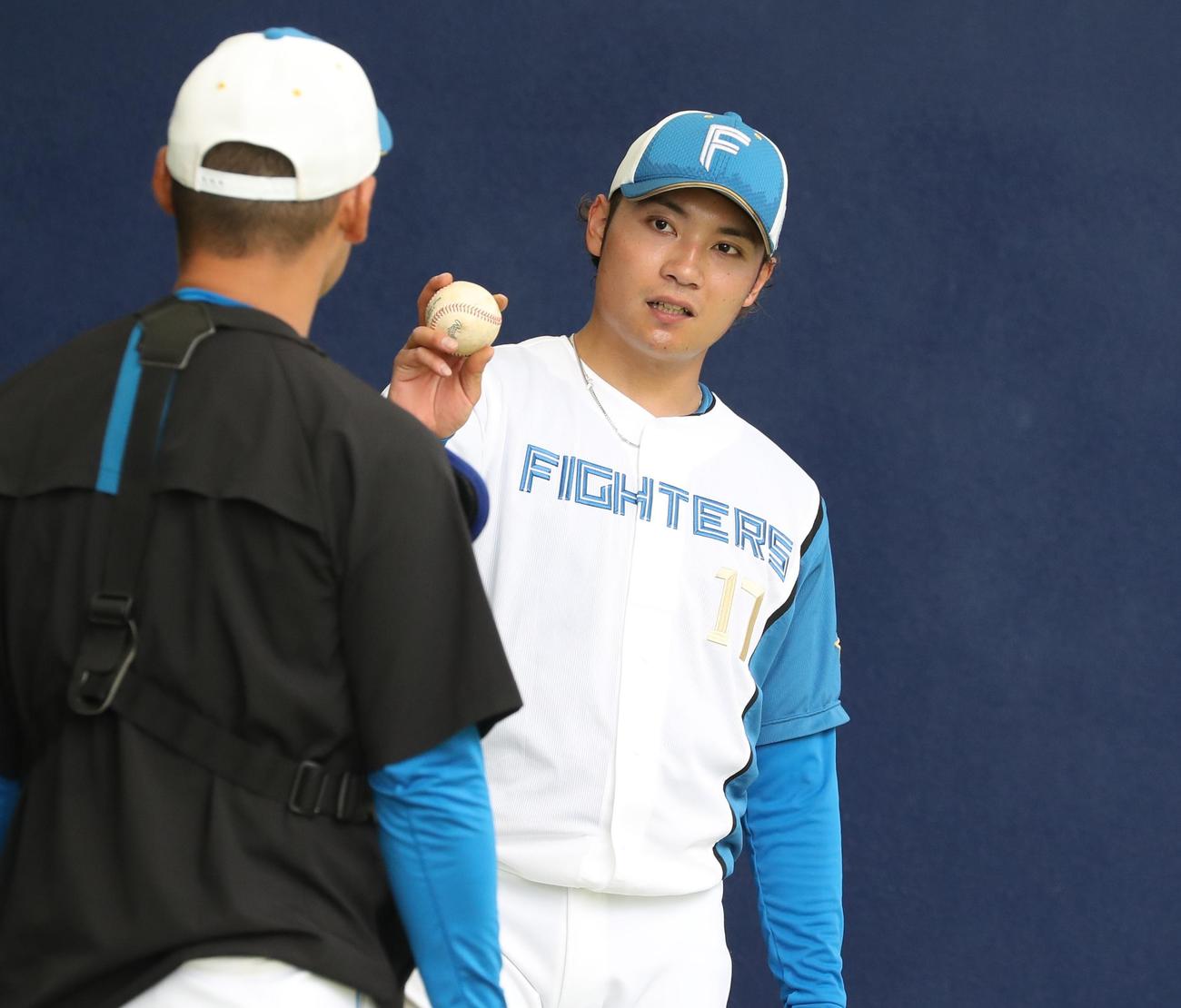 ブルペンで投球後、捕手と話す日本ハム伊藤（撮影・黒川智章）