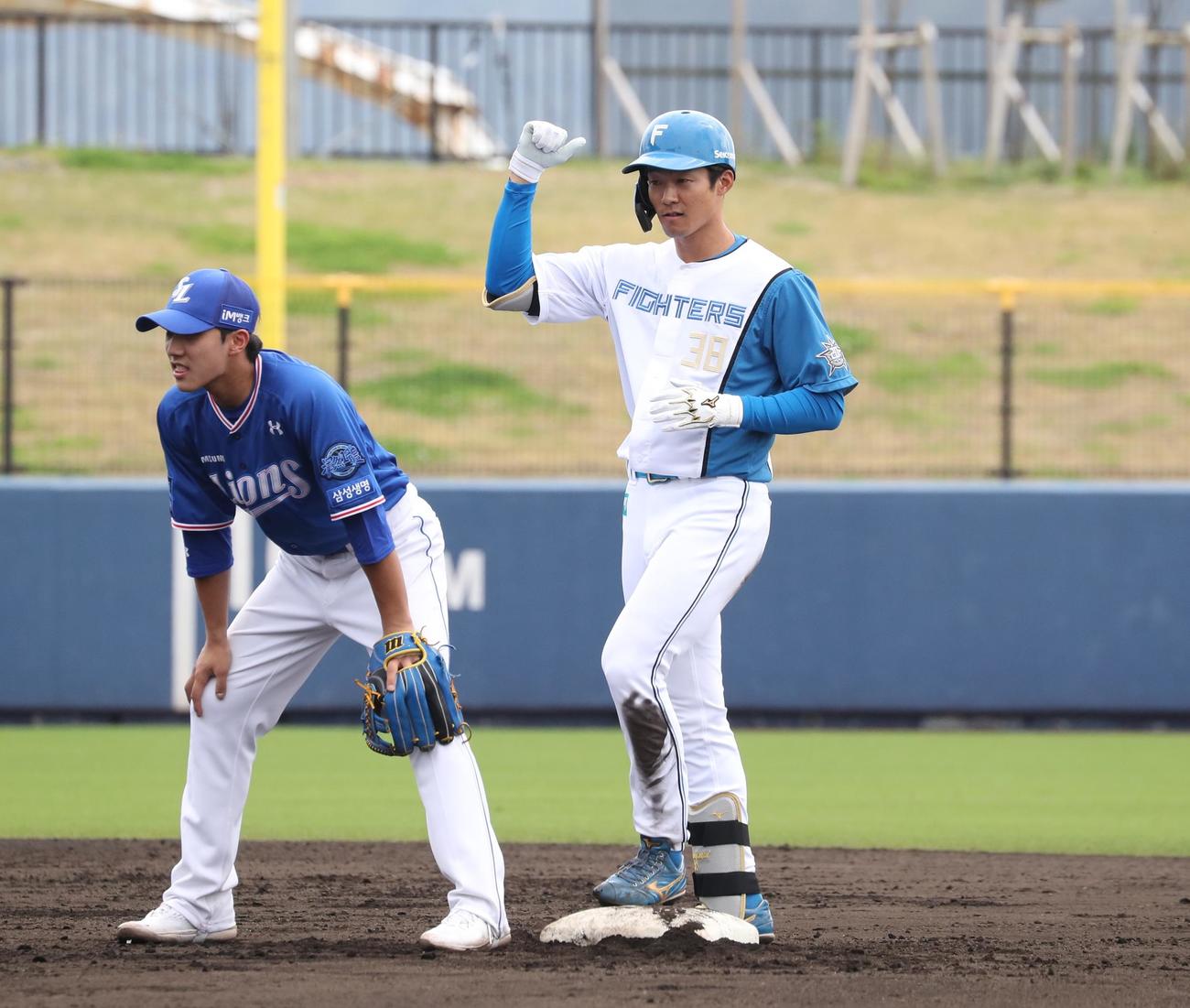 日本ハム対サムスン　4回裏日本ハム2死二塁、右前適時打を放ちガッツポーズの石井（撮影・黒川智章）
