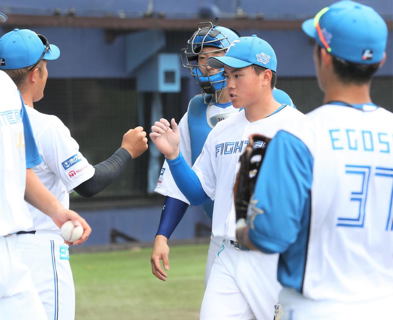 日本ハム対サムスン　2回表、打者を3人で抑えナインに出迎えられる畔柳（撮影・黒川智章）