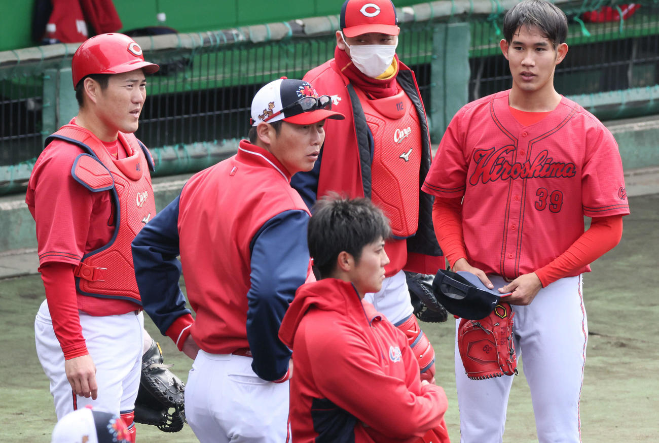 広島日南キャンプ　ランチタイム特打1番手で登板したドラフト3位の益田（右）に話しかける新井監督（右から3人目）。左は磯村（撮影・加藤孝規）
