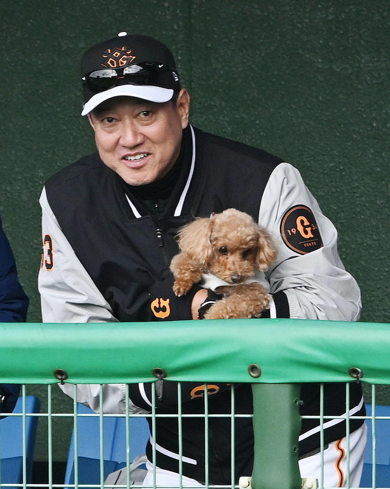 練習前にベンチで犬を抱く巨人原監督（撮影・滝沢徹郎）