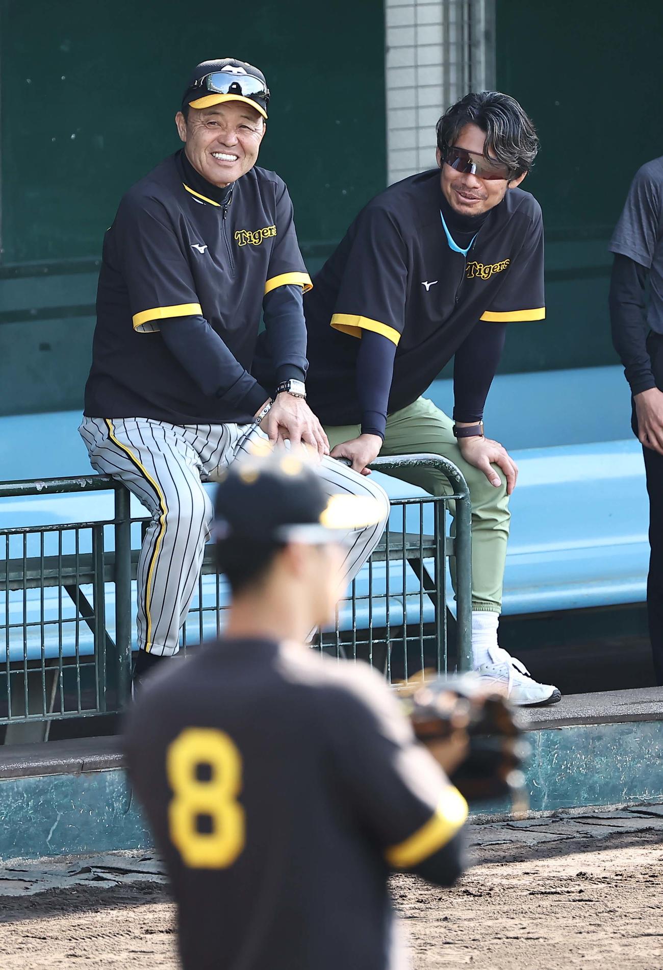 ベンチで笑顔を見せる岡田監督（左）と鳥谷臨時コーチ。手前は佐藤輝（撮影・上田博志）