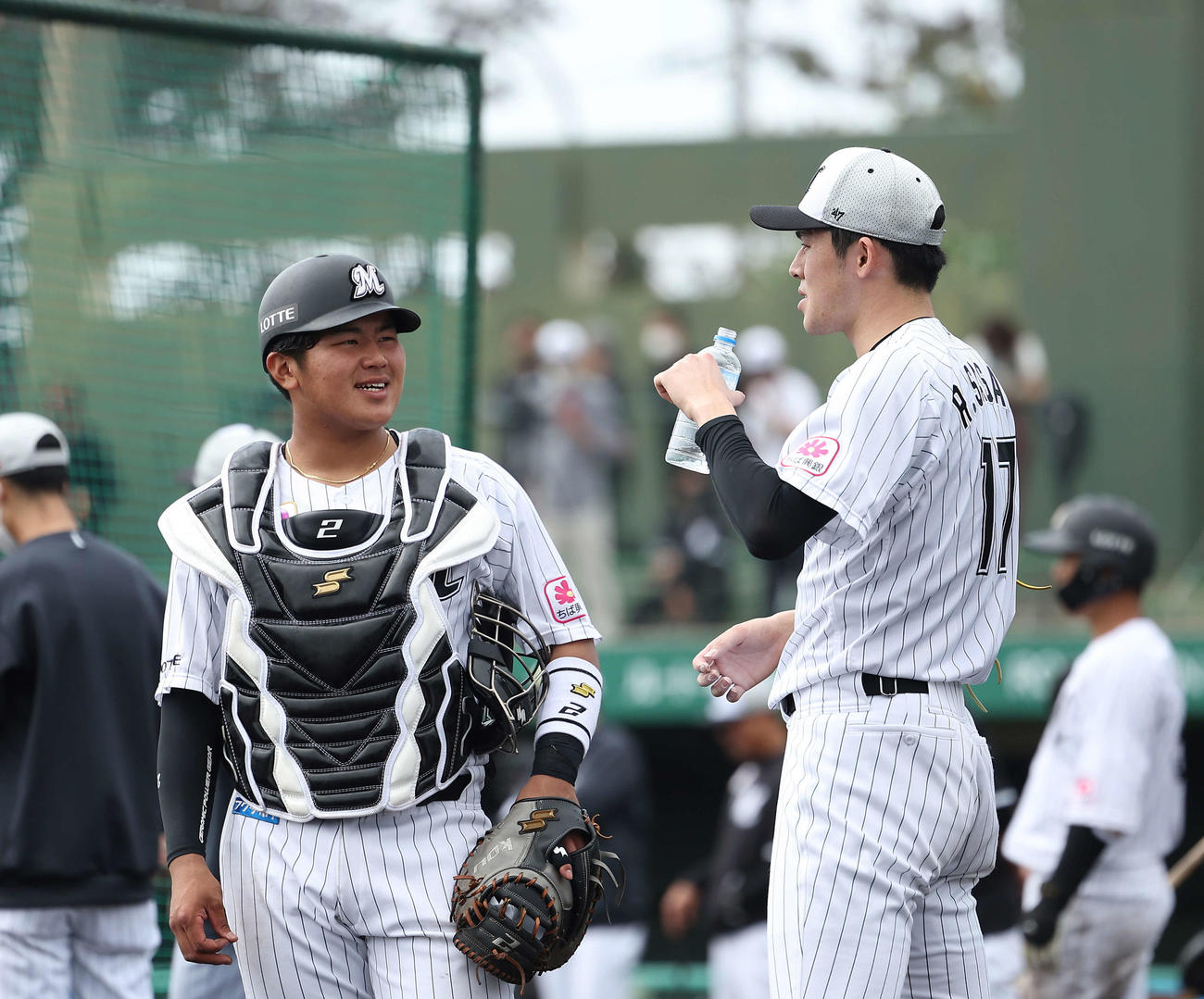 実戦形式の打撃練習後、言葉を交わすロッテ松川（左）と佐々木朗（撮影・河田真司）