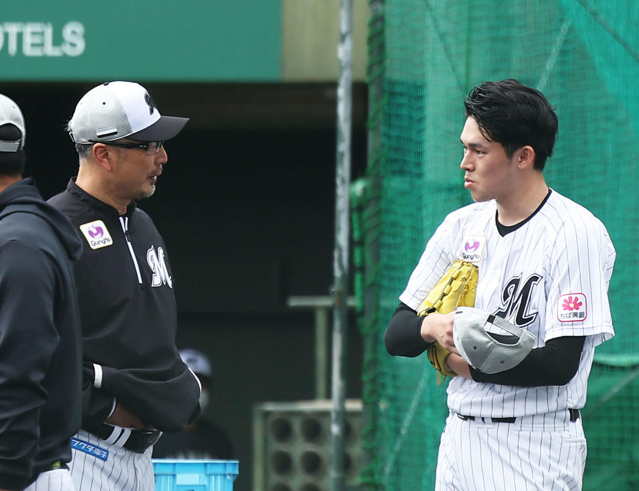 実戦形式の打撃練習後、吉井監督（左）と言葉を交わすロッテ佐々木朗（撮影・河田真司）