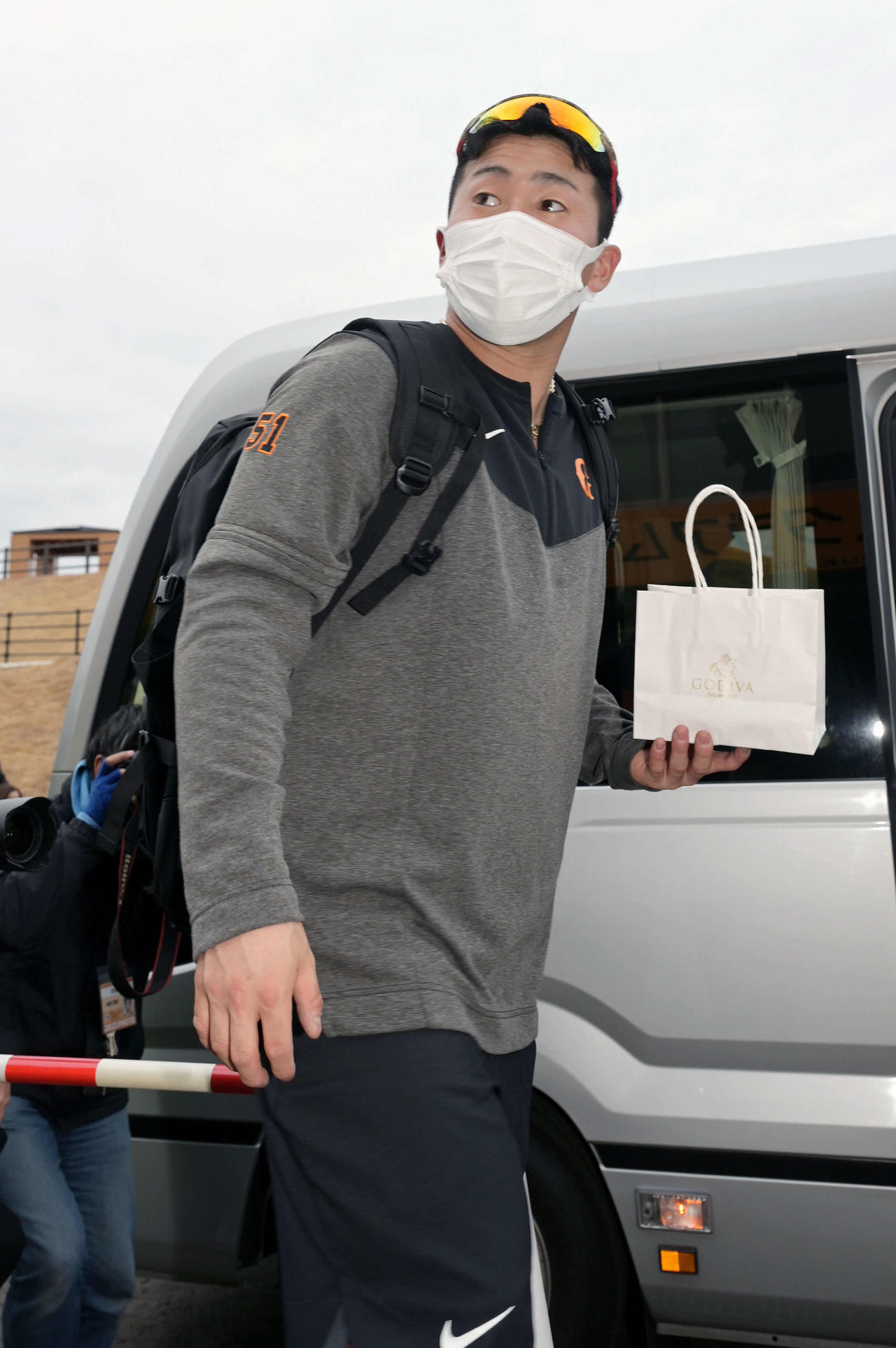 ファンからもらったプレゼントを手に帰りのバスに乗り込む巨人ドラフト1位浅野（撮影・滝沢徹郎）