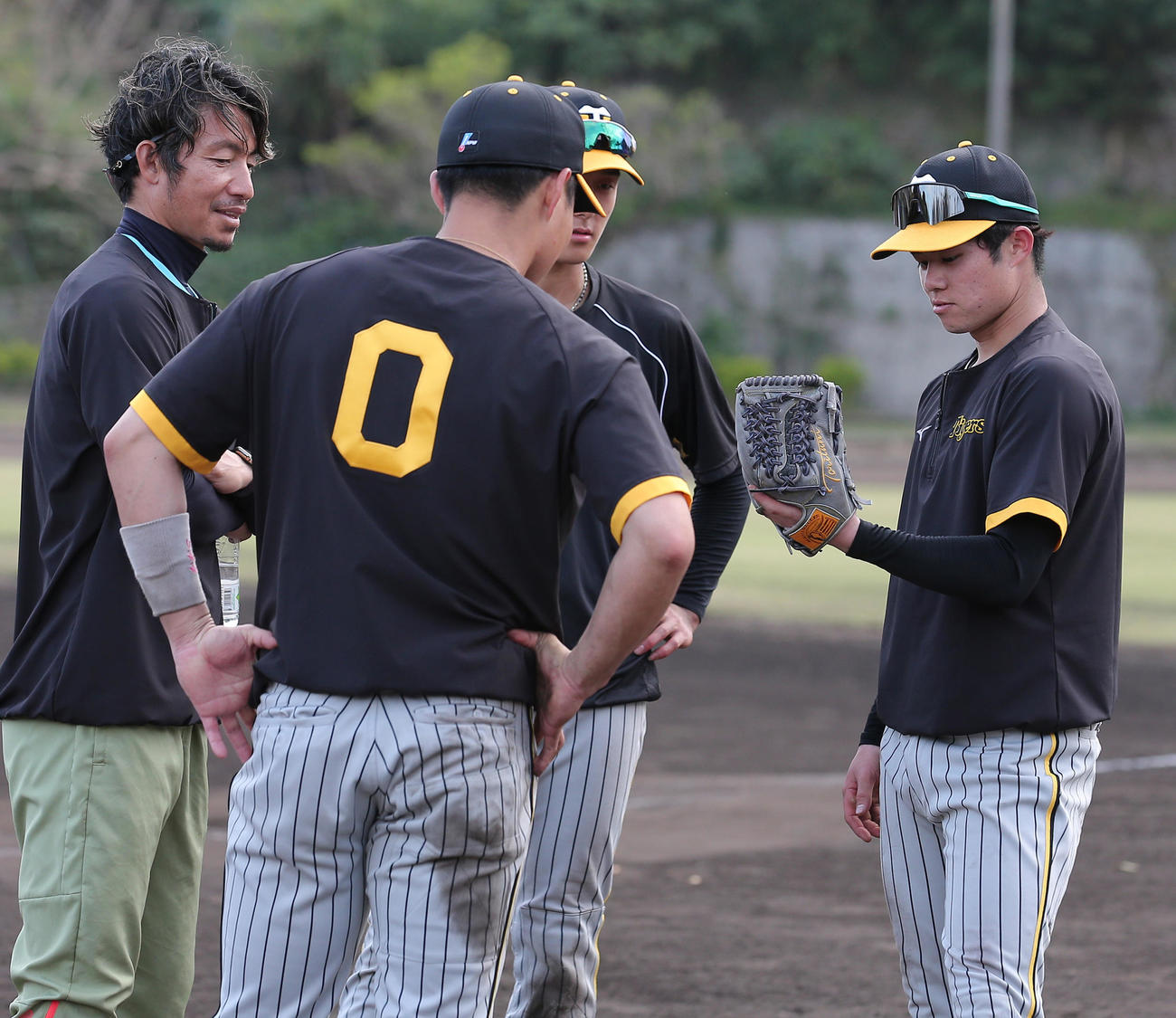 鳥谷臨時コーチ（左から3人目）のグラブに興味を示す中野（右）ら（撮影・上山淳一）