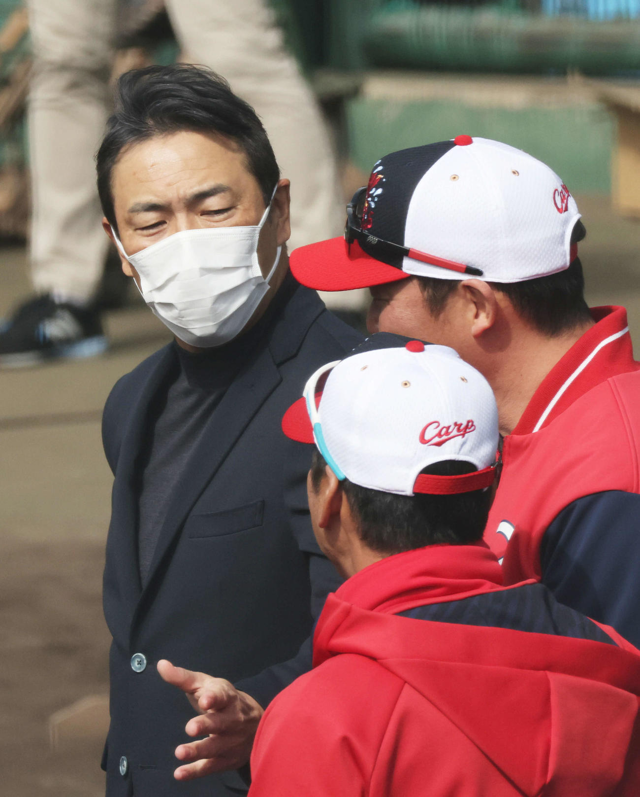 広島日南キャンプ　新井監督（右）、藤井ヘッドコーチ（手前）と話し合う黒田球団アドバイザー（2023年2月4日）