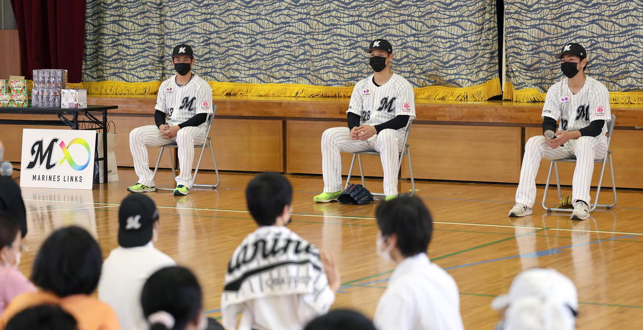 八重山特別支援学校の子供たちと交流するロッテの3選手。左から秋山、菊地、吉川（球団提供）
