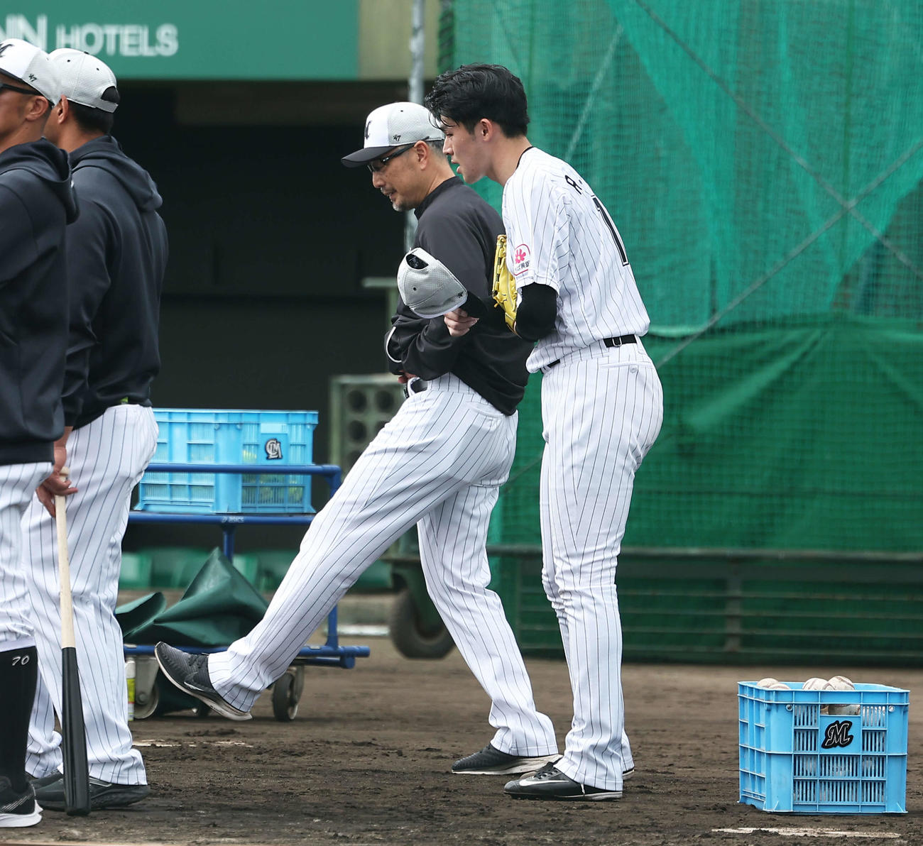 実戦形式の打撃練習後、吉井監督（左）と言葉を交わすロッテ佐々木朗（撮影・河田真司）
